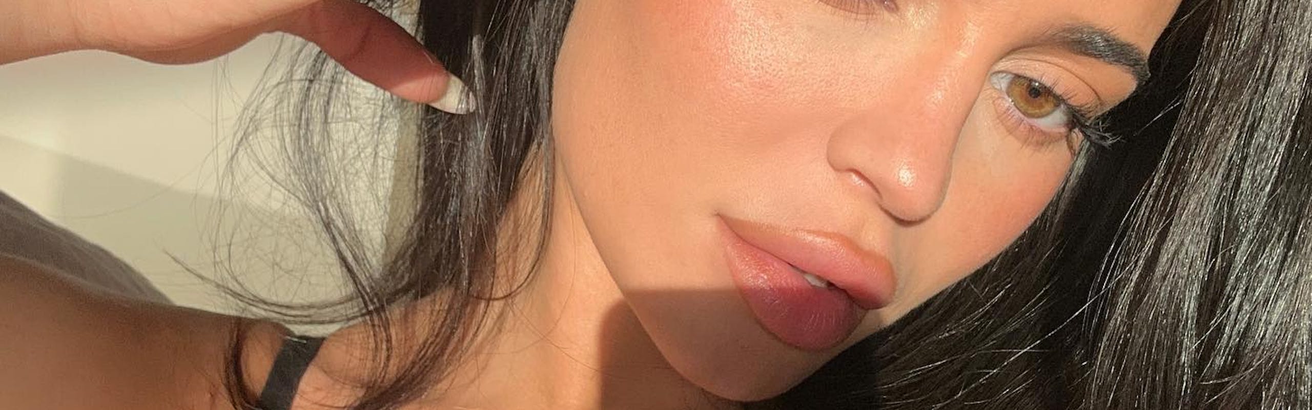 Kylie Jenner taking a selfie with a nude lip and a slightly winged eyeliner.