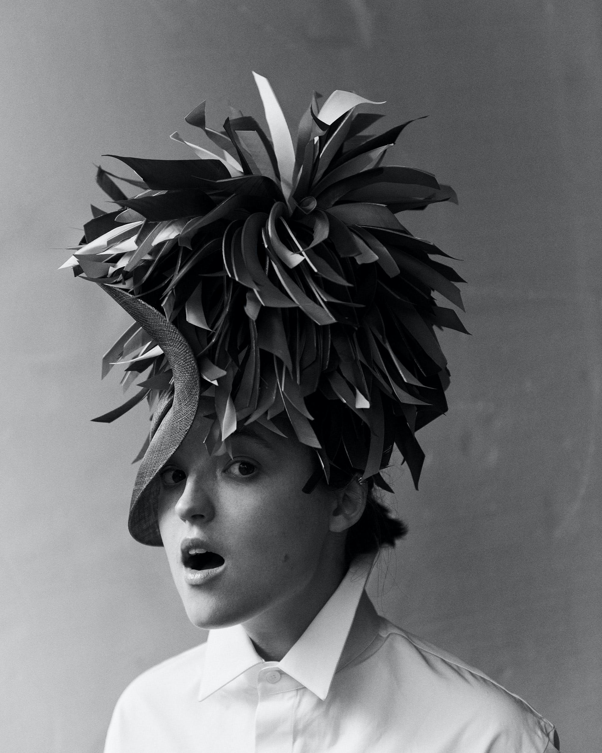 Bella Ramsey wearing a sculptural hat in an editorial for L'OFFICIEL.