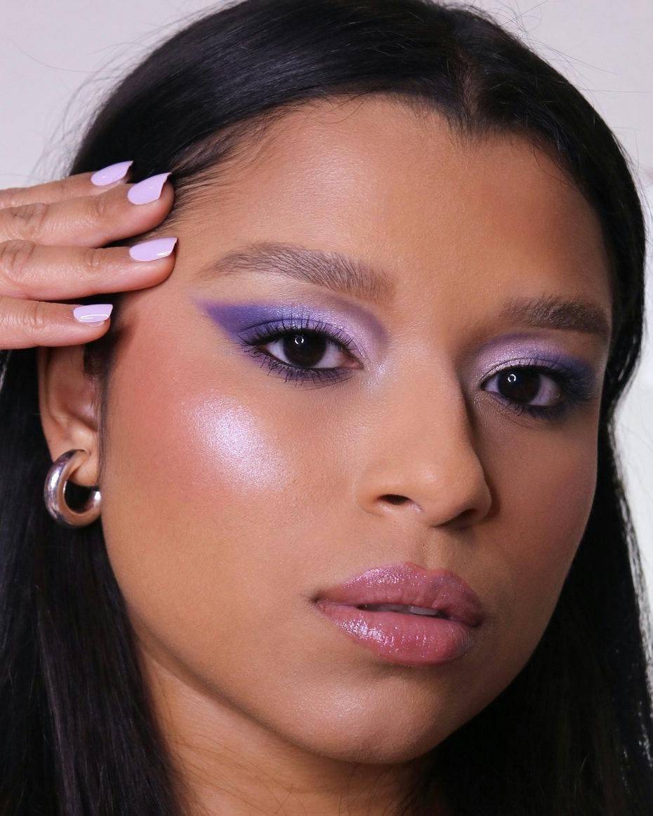 A model with purple eyeshadow looking at the camera.
