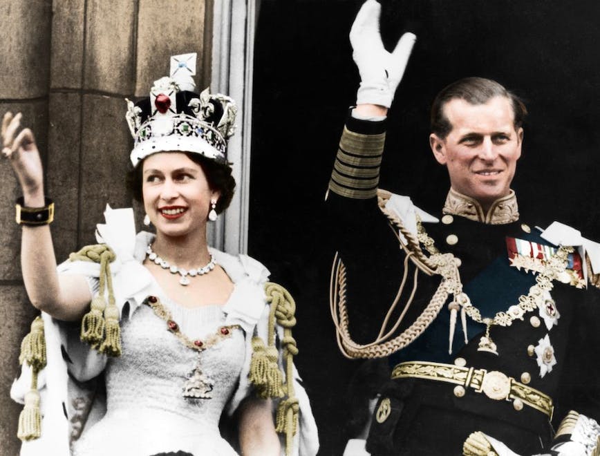 Queen Elizabeth and her husband waving to the crowd.