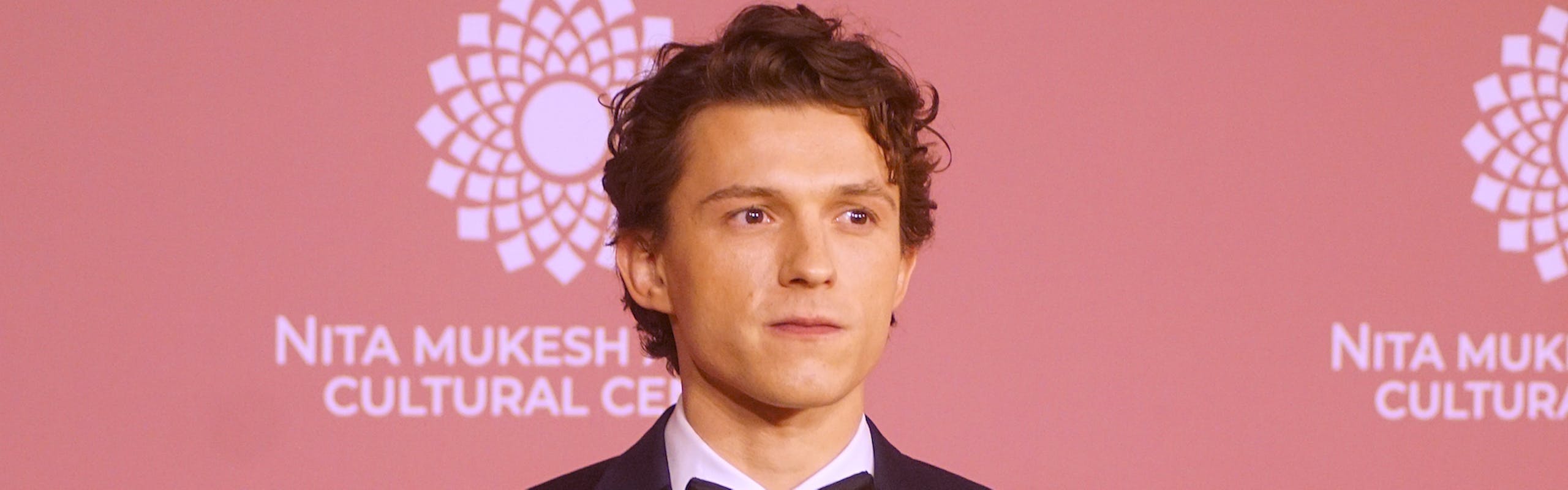 Tom Holland at Entertainment in India in a black suit and bowtie.