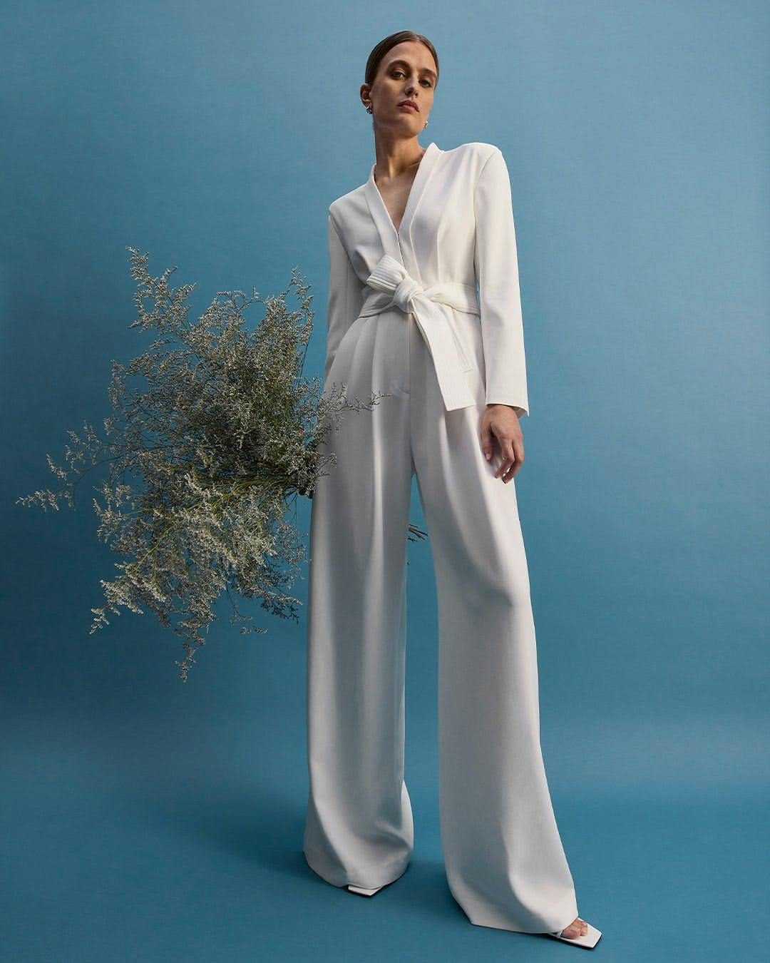 A model in a white bridal jumpsuit.
