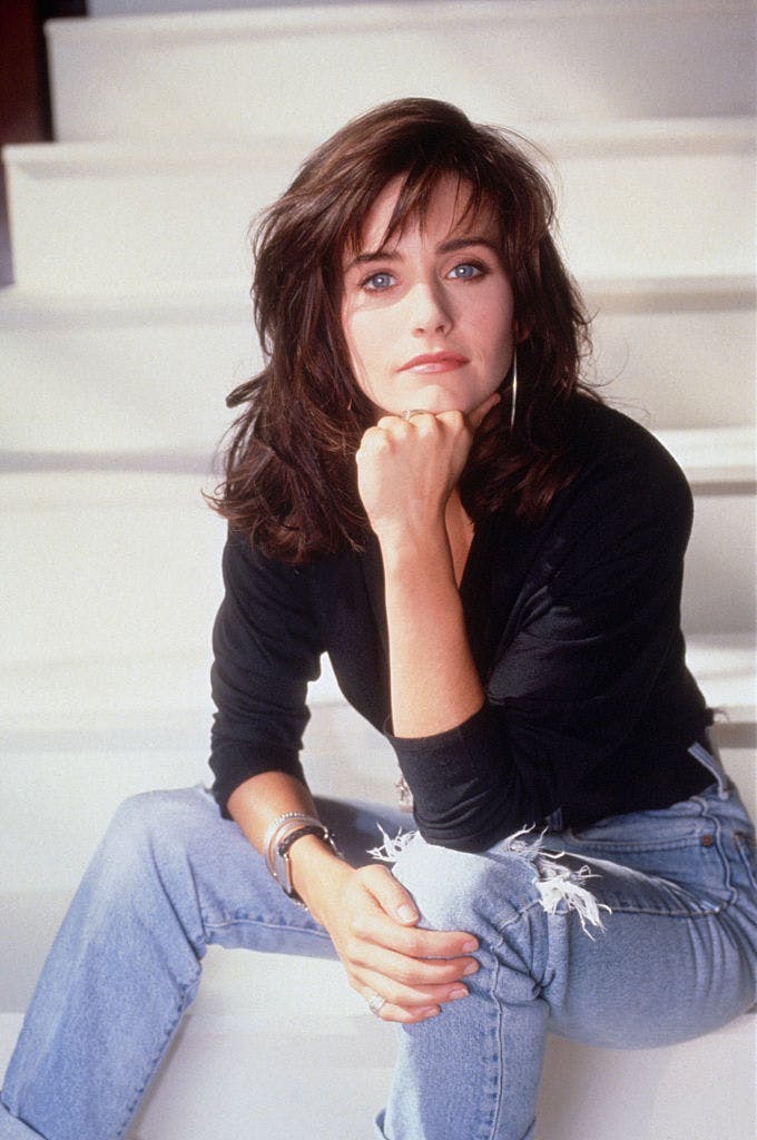 Courteney Cox in a black turtleneck and jeans.
