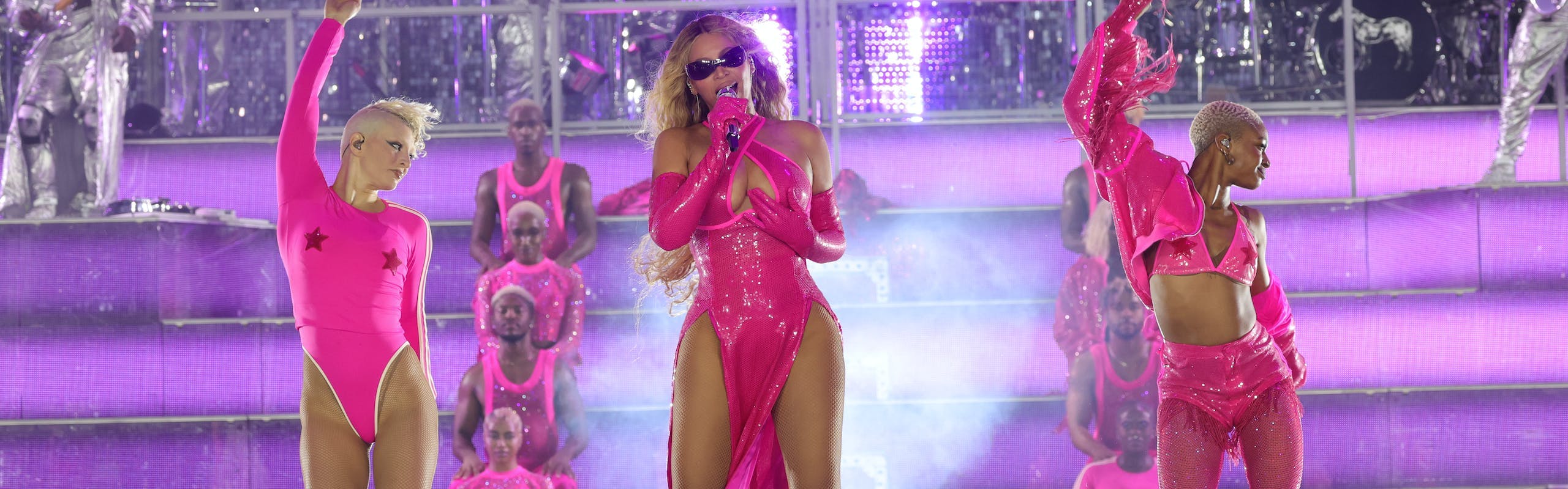 Beyonce performing in a pink dress with side slits.