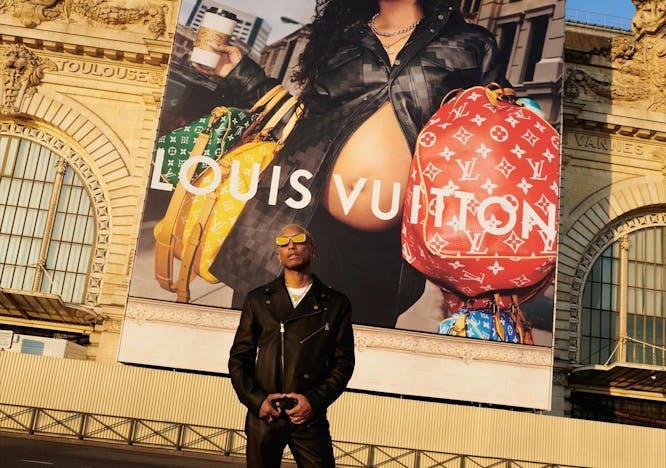 Pharrell Williams in front of a Louis Vuitton campaign.
