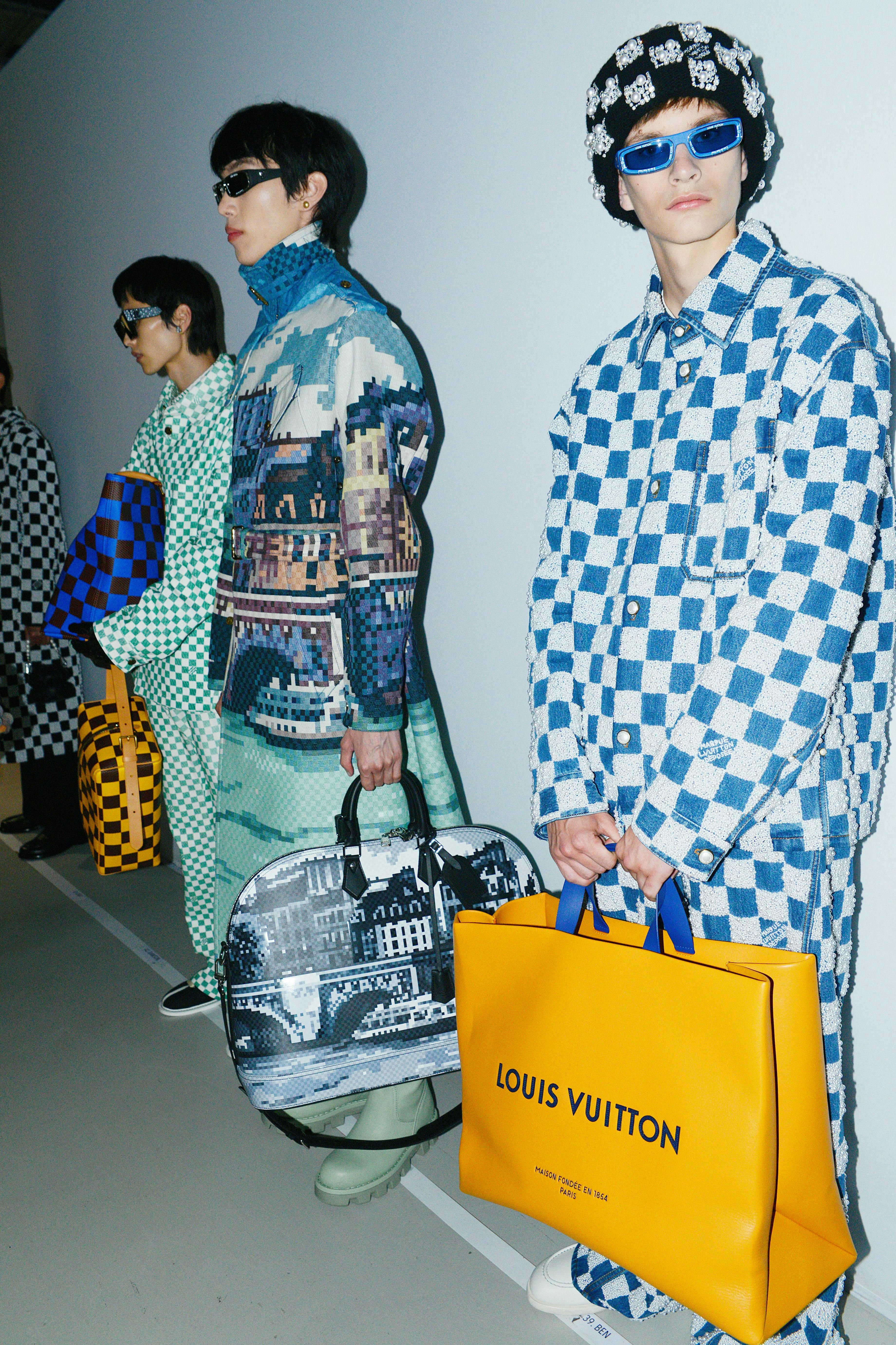A model in a checker jacket holding a yellow tote bag.
