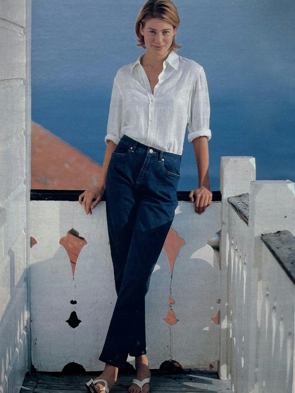 Woman wears white button down and blue jeans