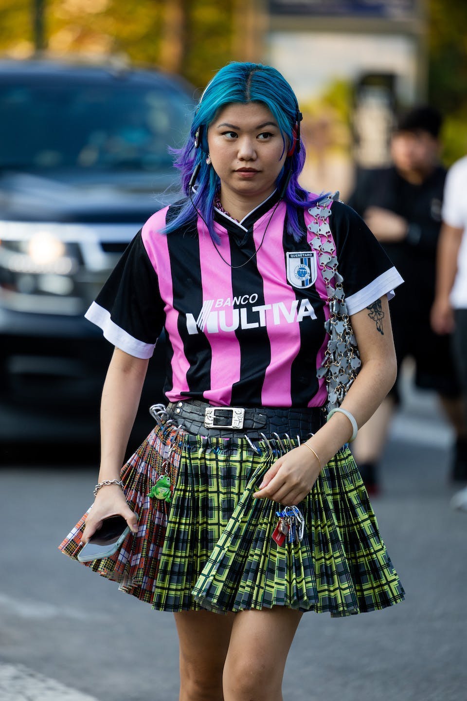 woman in blokecore trend pink and black jersey and green skirt