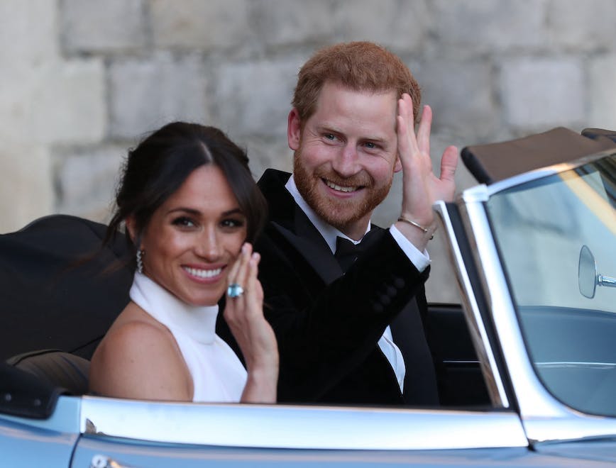 Prince Harry and Meghan Markle waving from car.