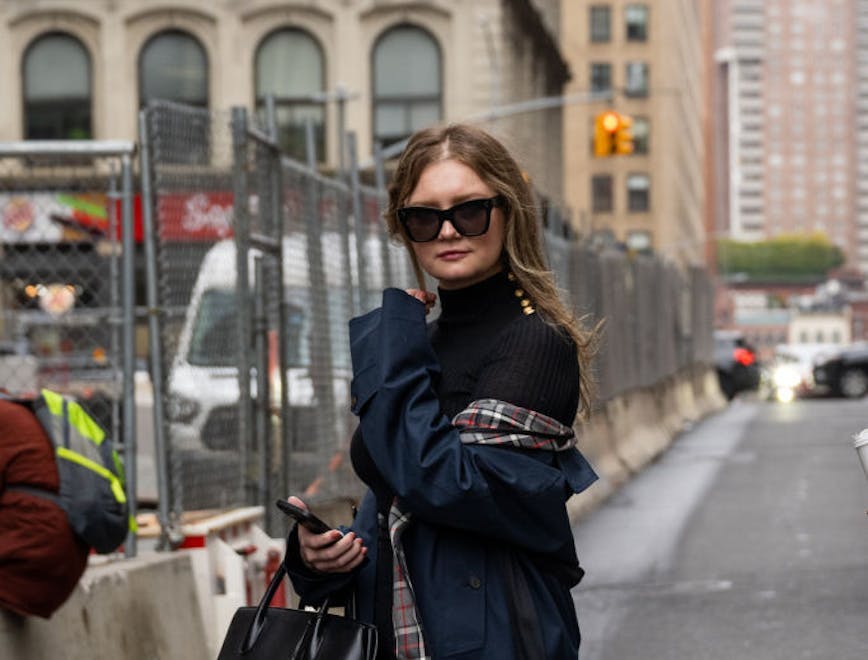 anna delvey in black and plaid trench coat; producing runway show kelly cutrone