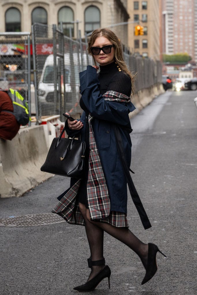 anna delvey in black and plaid trench coat; producing runway show kelly cutrone