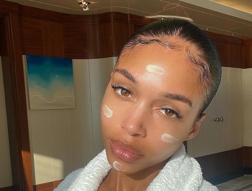 lori harvey in a white robe with cleansing oil