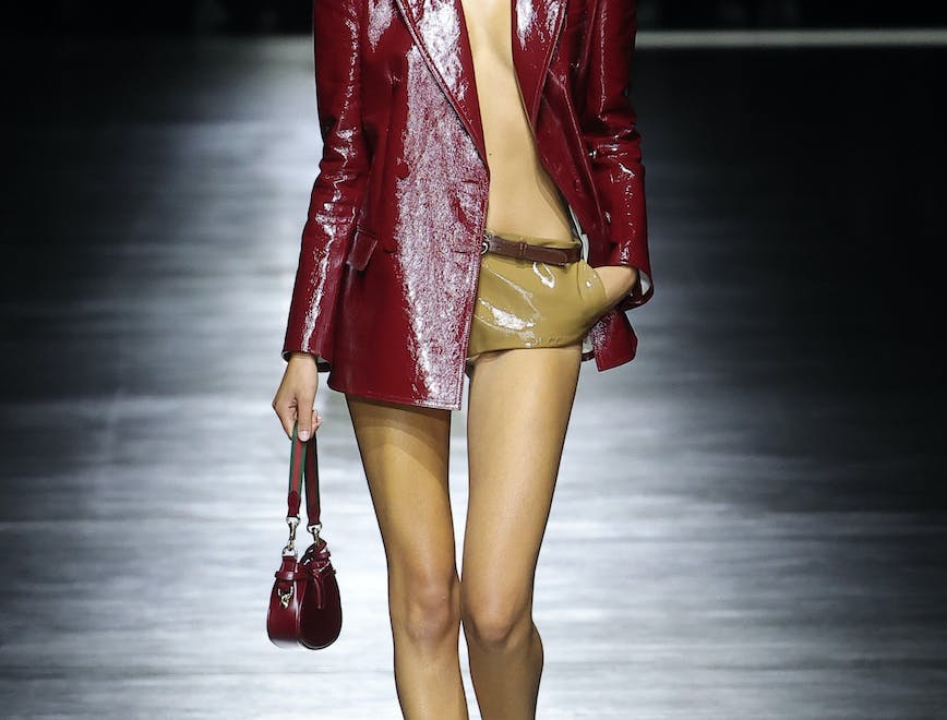 model in red patent leather jacket and mini shorts
