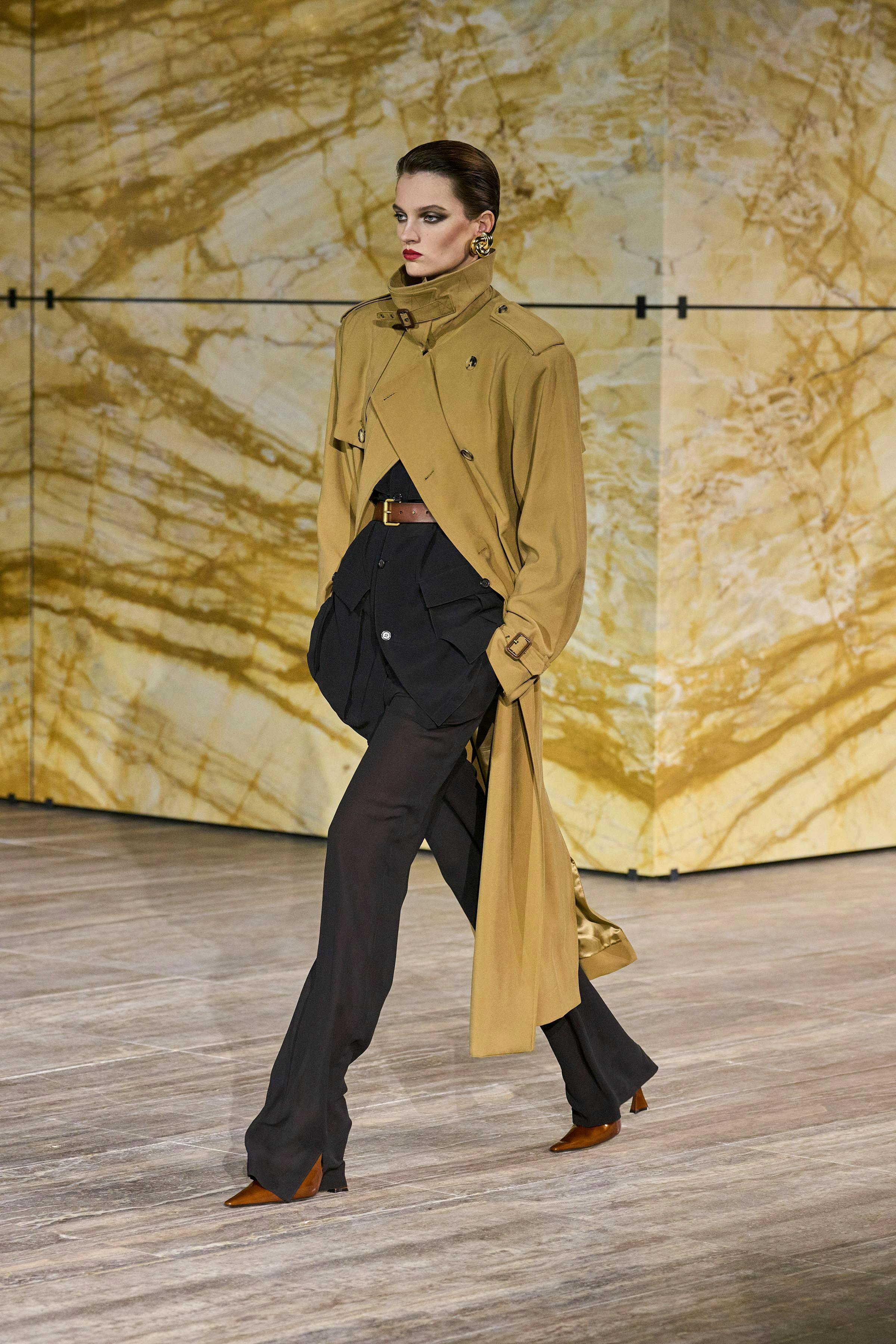 model in deconstructed trench coat and high waisted black pants
