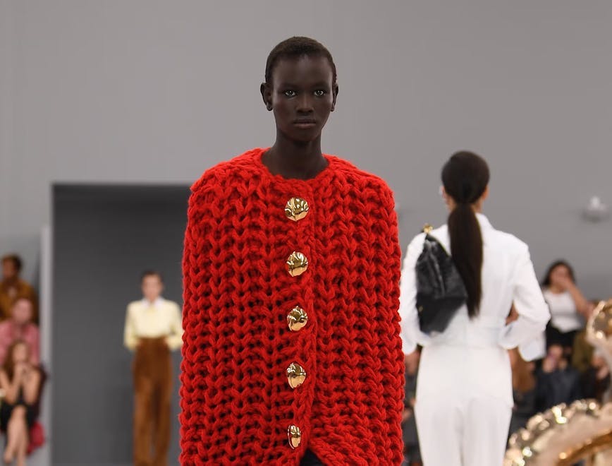 model in red chuky knit cape coat and pants