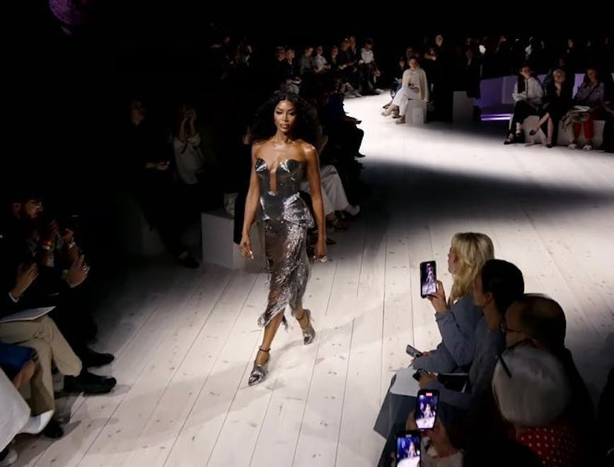 naomi campbell in a silver dress walking down the runway