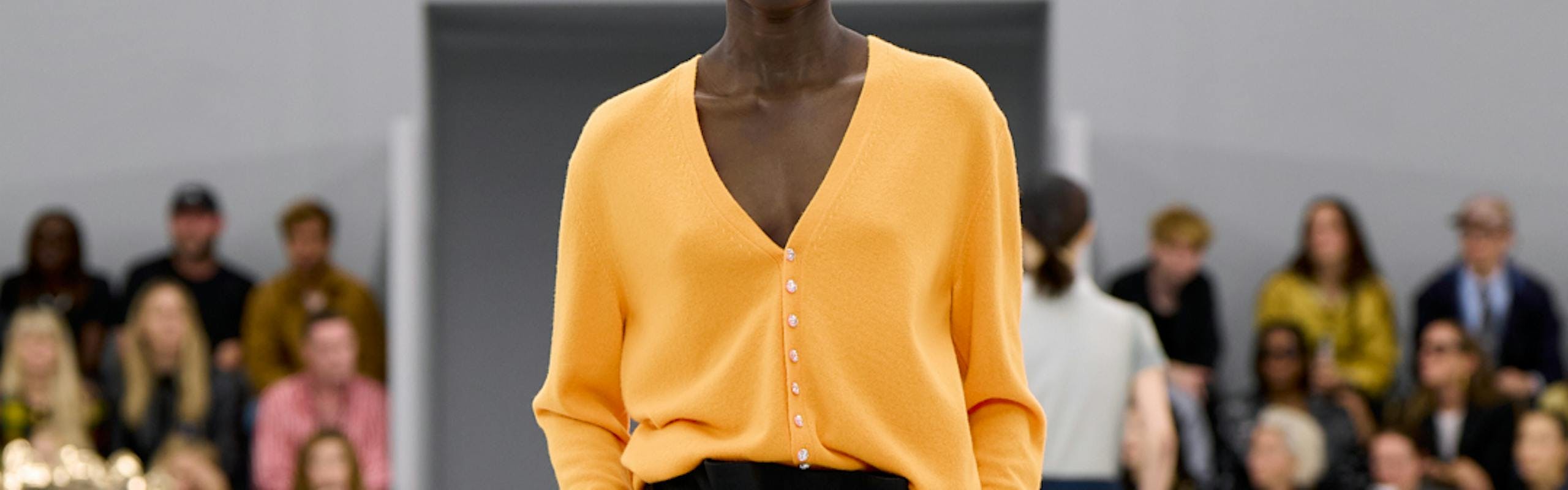 model in orange top and black shorts