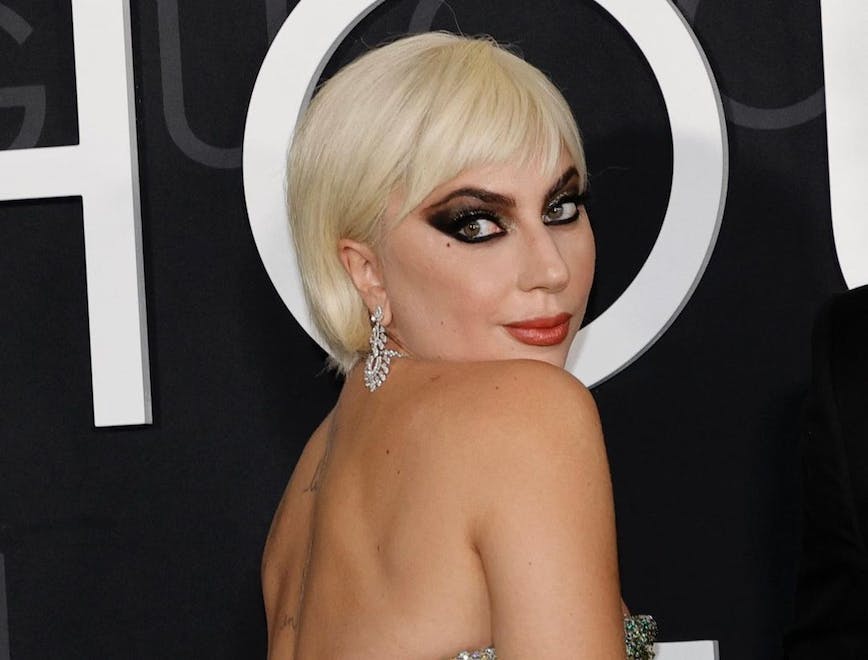 lady gaga looking over her shoulder in gold sequin dress
