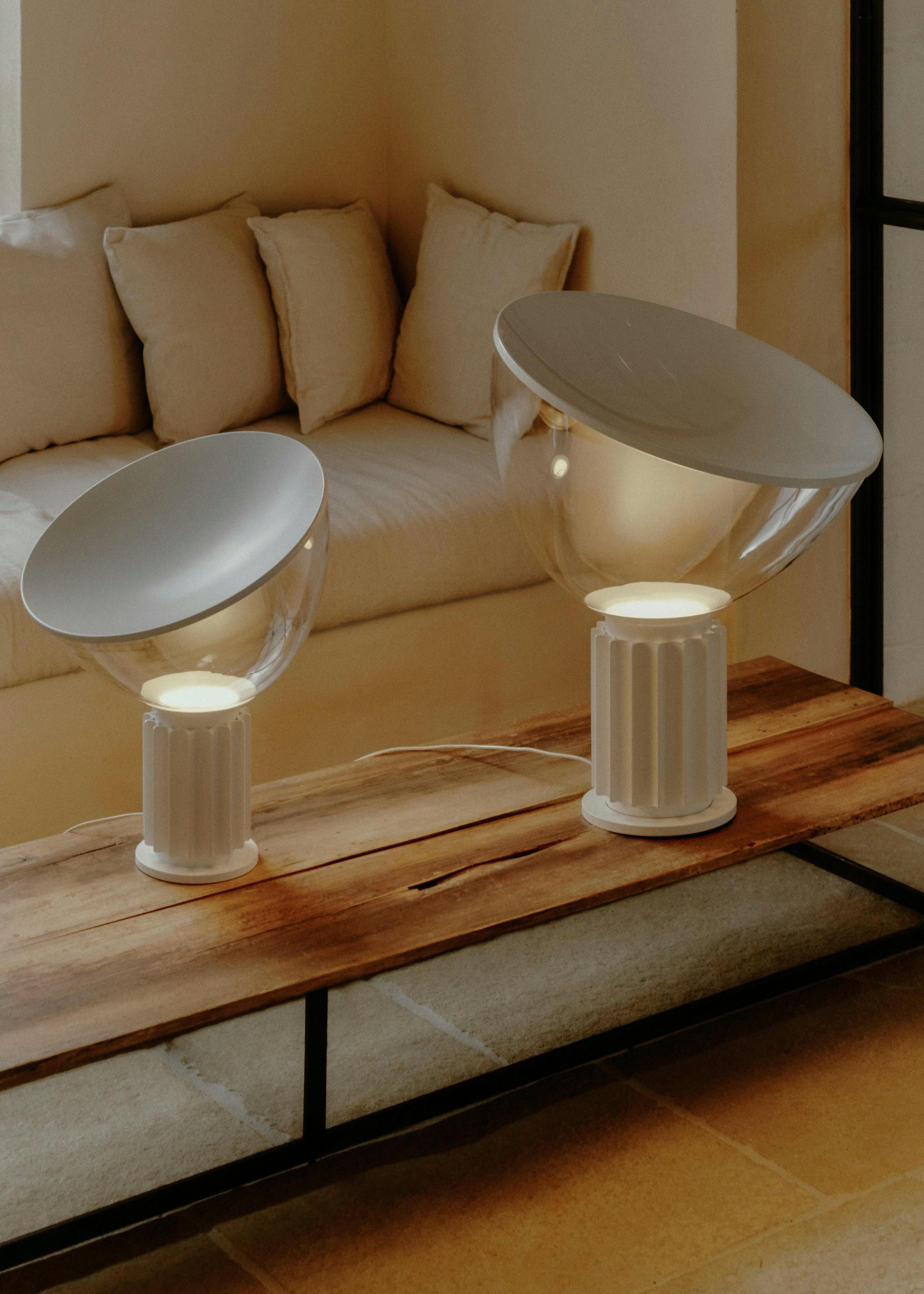 flos' matte white taccia table lamp on a light wooden table
