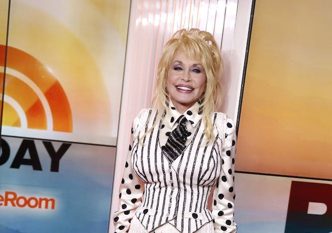dolly parton in black and white vest, polka dot shirt, and fringe pants