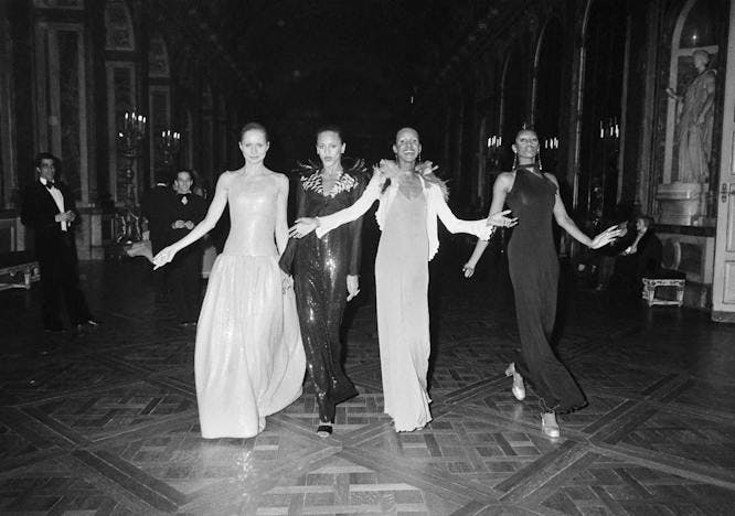 black and white photo of four models wearings designs from the show