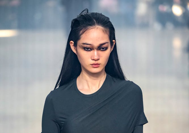 Fall/Winter 2024 Beauty Trends: a model walking the runway wearing a dark grey dress for helmut lang fall/winter 2024.