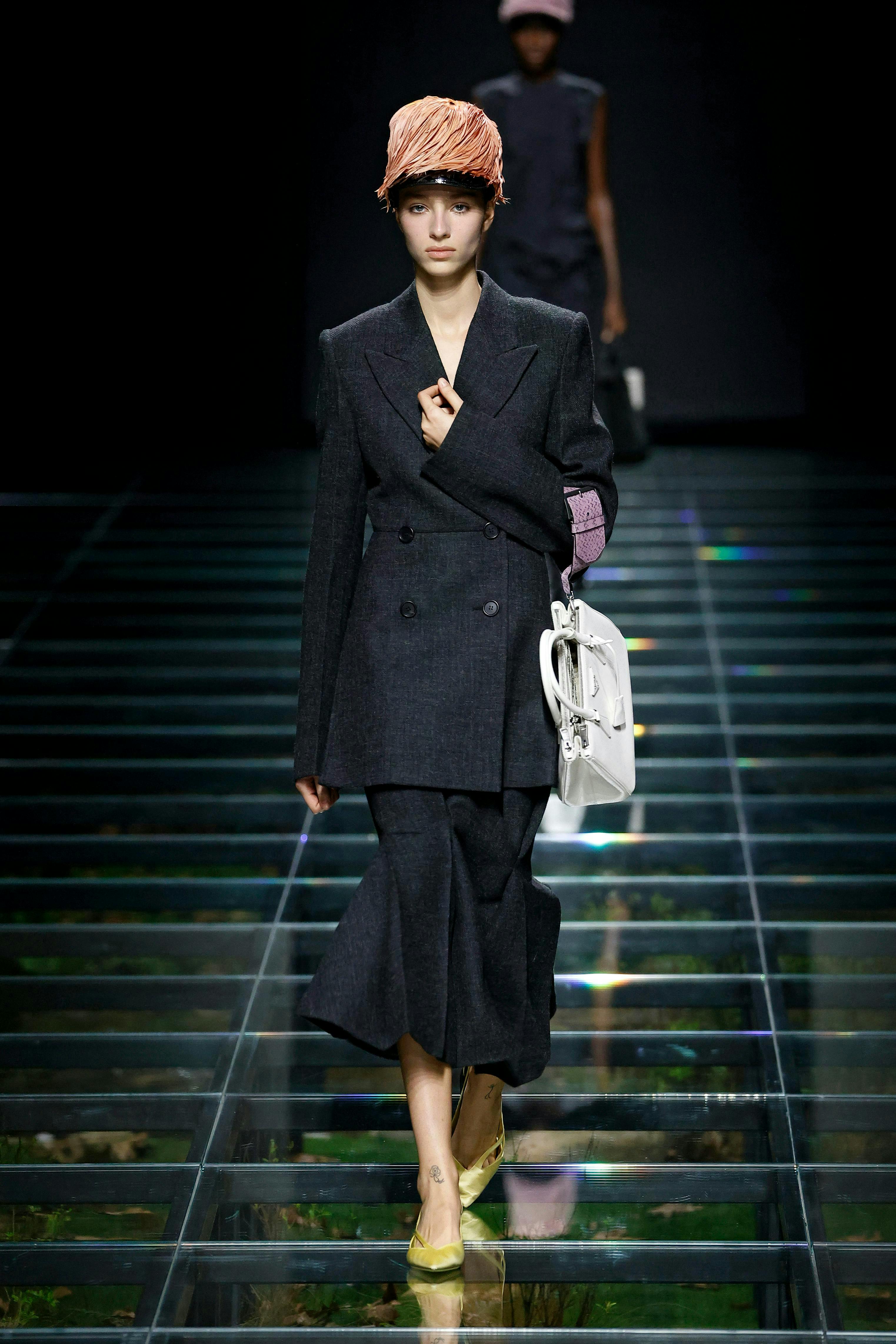 model on runway wearing black blazer and skirt