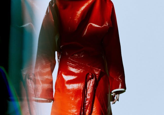 A model in an oversized red leather top and wrap skirt