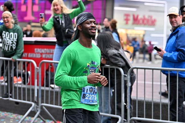 Lil Nas X running the 2024 NYC Half Marathon in a green shirt and black shorts