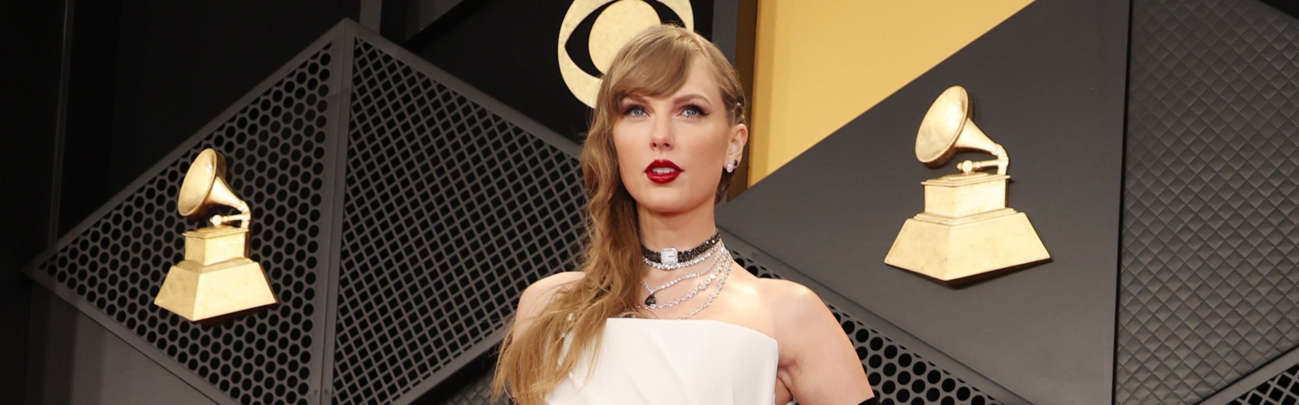 taylor swift net worth 2024: Taylor Swift wearing a white gown and black gloves at the 2024 Grammys