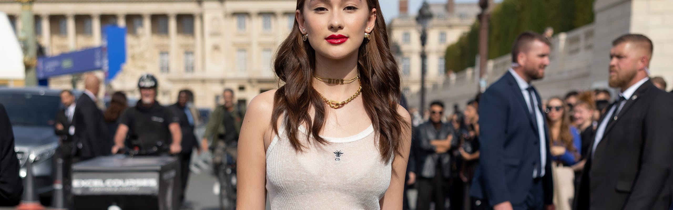 lola tung facts: Lola Tung at the Christian Dior Spring/Summer 2024 show wearing a white sheer top and skirt